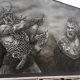 Czarno biały mural na elewacji budynku, wikingowie w boju