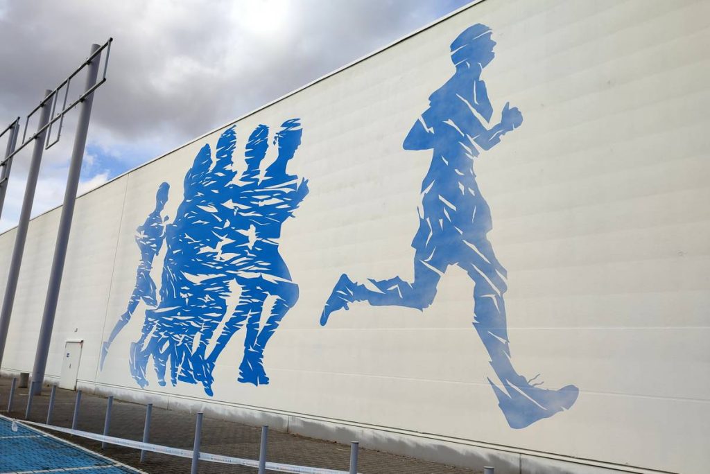 Mural o tematyce sportowej namalowany dla Decathlon w Poznaniu, mural promujący sportowy tryb życia