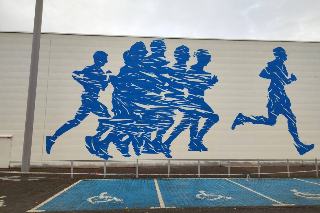 Mural reklamowy, Malowanie biegaczy mural dla Decathlonu namalowany w Poznaniu, tematyka promująca sport