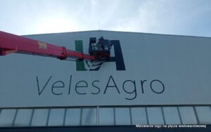 Malowanie logo na hali z płyty warstwowej, loga i oznaczenia na halach i magazynach