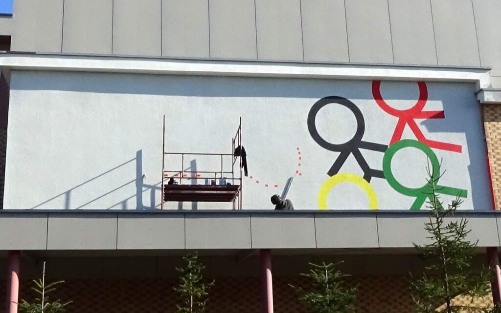 Malowanie logotypu na ścianie w szkole w Toruniu, malowanie murali i logotypów