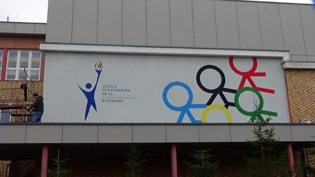 Malowanie logotypu na ścianie w szkole w Toruniu, malowanie murali i logotypów