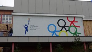 Malowanie logotypu na ścianie w szkole w Toruniu, malowanie murali i logotypów