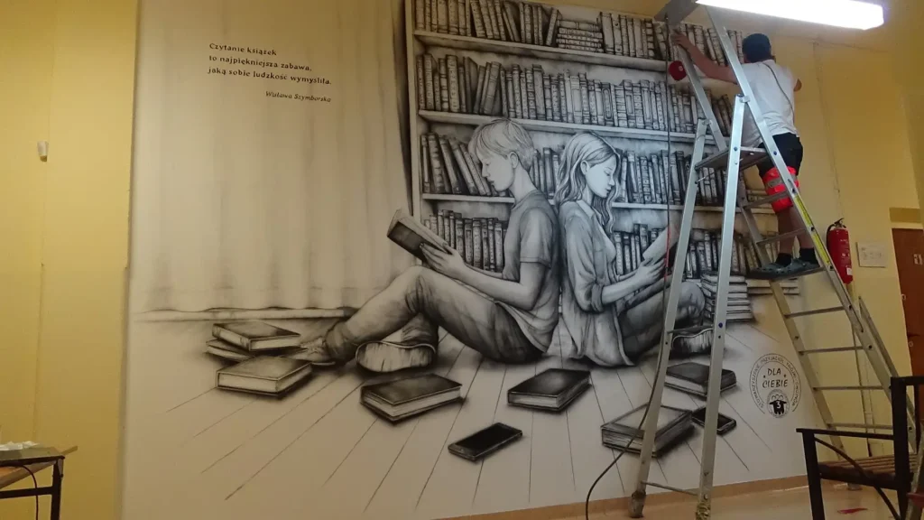Mural o tematyce edukacyjnej, mural promujący czytelnictwo namalowany w szkole w Chojnowie