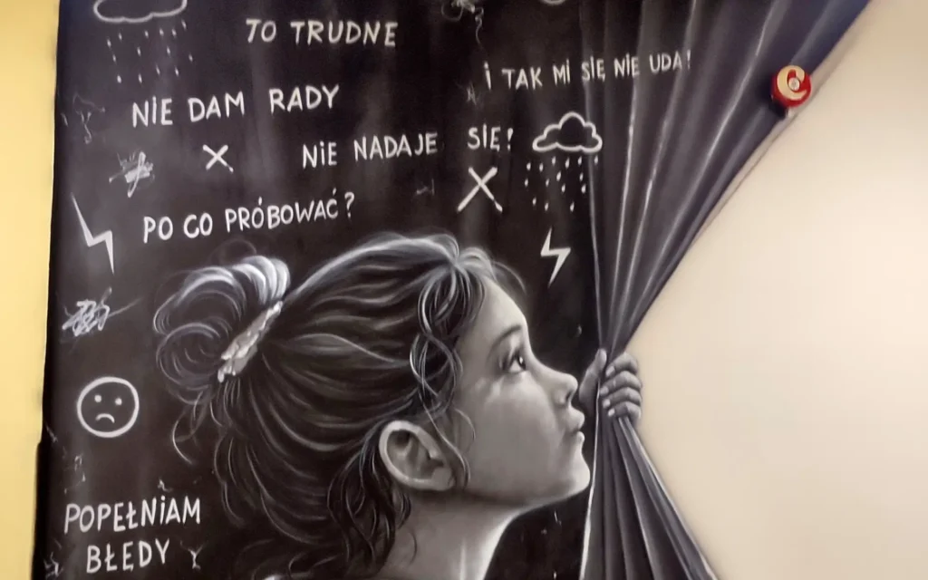 Mural motywacyjny z przeslaniem namalowany w szkole na korytarzu, dziewczynka i jej myśli