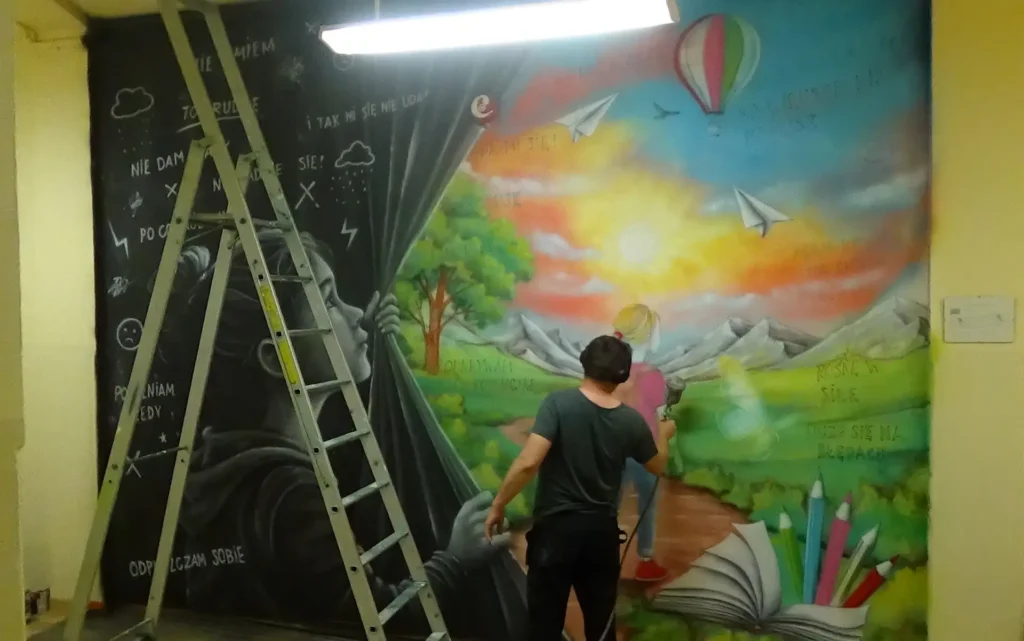 Mural motywacyjny z przeslaniem namalowany w szkole na korytarzu, dziewczynka i jej myśli